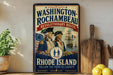 A vintage-style metal sign with the text "WASHINGTON-ROCCHAMBEAU REVOLUTIONARY ROUTE" and "RHODE ISLAND" is displayed on a shelf, accompanied by a wooden cutting board and a potted plant.