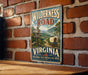 A vintage-style metal sign with the text "Wilderness Road" and "VIRGINIA" is displayed on a brick wall.
