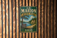 A vintage metal sign for A.W. Marion State Park in Ohio, featuring a scenic landscape with a lake and trees.