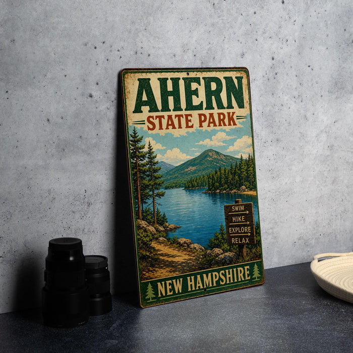 A vintage metal sign for Ahern State Park, featuring a scenic landscape with a lake, mountains, and pine trees.