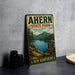 A vintage metal sign for Ahern State Park, featuring a scenic landscape with a lake, mountains, and pine trees.