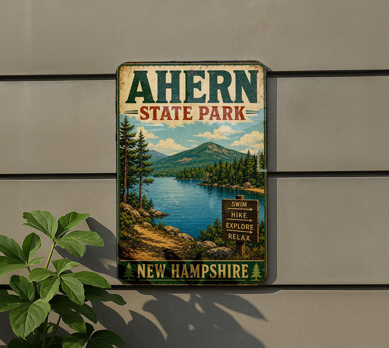 A vintage-style metal sign for Ahern State Park in New Hampshire, featuring a scenic landscape with a lake, mountains, and pine trees.