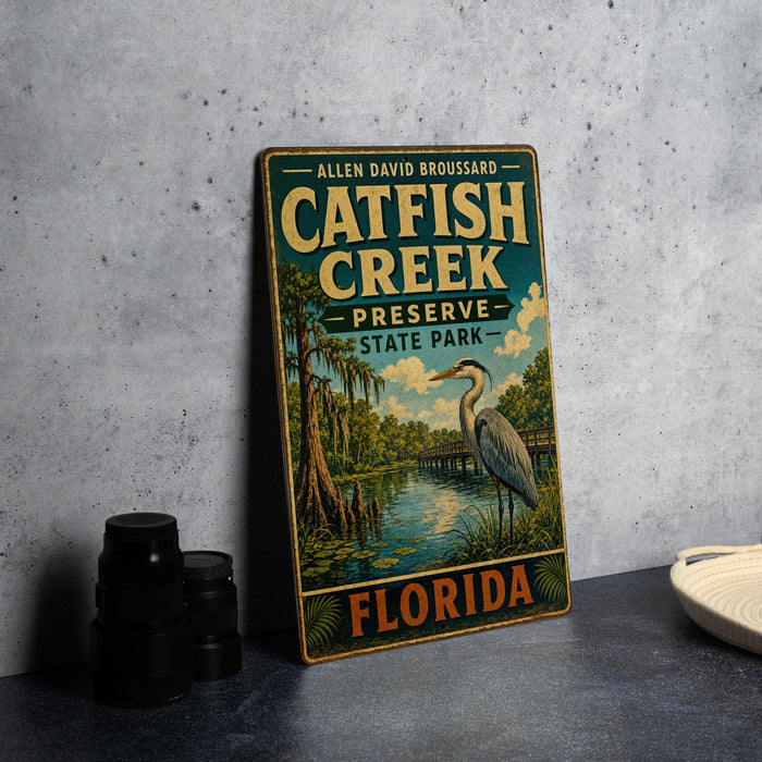 A vintage-style metal sign for the Catfish Creek Preserve in Florida, featuring an illustration of a bird and a pond surrounded by trees.