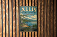 A vintage metal sign for Allis State Park in Vermont, featuring a scenic landscape with a lake and mountains.