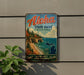 A vintage metal sign for Aloha State Park, Michigan, featuring a scenic landscape with a beach, cliffs, and a lake.