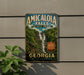A vintage-style sign for Amicola Falls State Park in Georgia, featuring a waterfall and lush greenery.