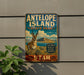 A vintage metal sign for Antelope Island State Park in Utah, featuring an illustration of a mountain and a gazelle.