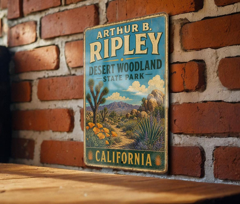 A vintage-style metal sign for Arthur B Ripley Desert Woodland State Park in California, featuring a desert landscape with mountains and cacti.