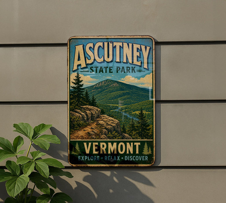 A vintage-style metal sign for Ascutney State Park in Vermont, featuring a scenic mountain landscape with pine trees and a winding path.