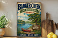 A vintage-style metal sign for Badger Creek State Recreation Area in Iowa, featuring a scenic illustration of a lake, canoe, and trees.