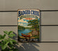 A vintage-style metal sign for Badger Creek State Recreation Area in Iowa, featuring a scenic illustration of a lake, canoe, and surrounding nature.