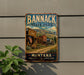 A vintage metal sign for Bannack State Park in Montana, featuring a scenic illustration of a small town with a wooden building, mountains in the background, and a flag.