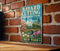 A vintage metal sign for Bayard Cutting Arborretum State Park in New York, featuring a scenic landscape with a bridge, flowers, and a pond.