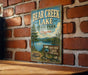 A vintage metal sign for Bear Creek Lake State Park in Virginia, featuring a scenic illustration of the lake surrounded by trees and mountains.