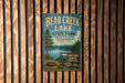 A vintage metal sign for Bear Creek Lake State Park in Virginia, featuring a scenic illustration of the lake and surrounding landscape.