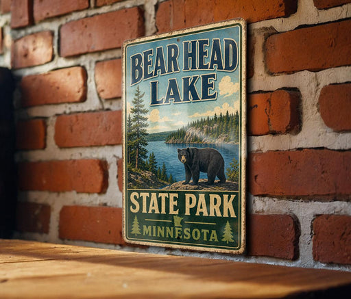 A vintage metal sign for Bear Head Lake State Park in Minnesota, featuring a bear and a scenic landscape.