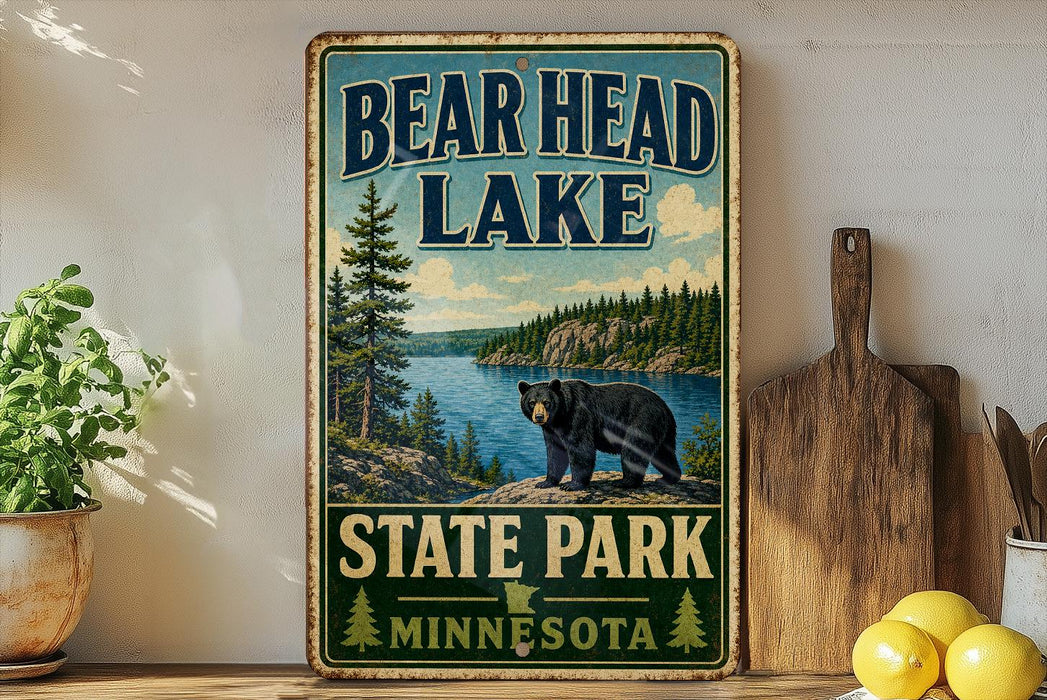 A vintage-style metal sign for Bear Head Lake, featuring a bear and a scenic landscape, is displayed on a shelf next to a wooden cutting board and some lemons.