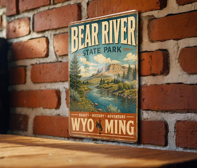 A vintage-style metal sign for Bear River State Park, featuring a scenic illustration of the river and mountains, mounted on a brick wall.