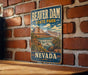 A vintage-style metal sign for Beaver Dam State Park in Nevada, featuring a scenic illustration of the park's landscape.