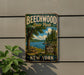 A vintage-style metal sign for Beechwood State Park, featuring a scenic image of a lake and forest, mounted on a wall.
