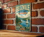 A vintage metal sign for Beltzville State Park in Pennsylvania, featuring a scenic image of a sailboat on a lake surrounded by mountains.