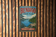A vintage metal sign for Bendigo State Park in Pennsylvania, featuring a scenic landscape with a lake and mountains.