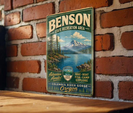 A vintage metal sign for Benson State Recreation Area, featuring a mountain landscape and a river, is displayed on a brick wall.