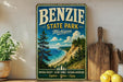 A vintage-style sign for Benzie State Park in Michigan, featuring a scenic landscape with pine trees, a beach, and a cliff overlooking the ocean.
