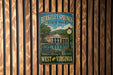 A vintage-style metal sign for Berkeley Springs State Park in West Virginia, featuring an illustration of the park's buildings and a clock.