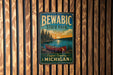 A vintage metal sign for Bewabic State Park, featuring a canoe and a scenic landscape, is displayed on a wooden wall.