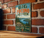 A vintage-style metal sign for Big Pocono State Park in Pennsylvania, featuring a scenic landscape with pine trees, a lake, and mountains.
