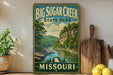 A vintage-style sign for Big Sugar Creek State Park in Missouri, featuring a scenic landscape with a river and mountains.