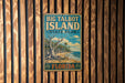 A vintage-style metal sign for Big Talbot Island State Park in Florida, featuring a tropical beach scene with palm trees and a large tree trunk.