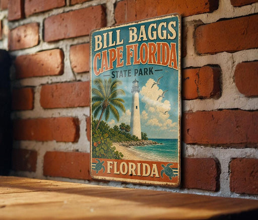 A vintage-style sign for Bill Bagg's Cape Florida State Park, featuring a lighthouse and palm trees, is displayed on a brick wall.