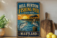 A vintage-style metal sign for Bill Burton Fishing Pier in Maryland, featuring an illustration of a fish jumping out of the water and a pelican perched on a wooden post.