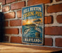 A vintage metal sign for Bill Burton Fishing Pier in Maryland, featuring an illustration of a pier with a pelican and a fish.