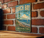 A vintage-style metal sign for Birch Bay State Park in Washington, featuring a scenic landscape with a sailboat on the water.