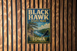 A vintage-style metal sign for Black Hawk State Park in Iowa, featuring a scenic landscape with a river, cliffs, and a bird in flight.