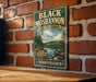 A vintage-style metal sign for Black Moshannon State Park in Pennsylvania, featuring a scenic landscape with a lake and mountains.