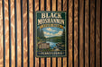 A vintage metal sign for Black Moshannon State Park in Pennsylvania, featuring a scenic landscape with pine trees and a lake.