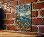 A vintage-style metal sign for Black Rock State Park in Connecticut, featuring a scenic landscape with a lake, mountains, and a sailboat.