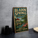 A vintage-style metal sign for Bl Donkey Springs State Park in Alabama, featuring a scenic illustration of the park and its surroundings.