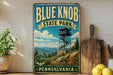 A vintage-style sign for Blue Knob State Park in Pennsylvania, featuring a scenic mountain landscape with a lookout tower.
