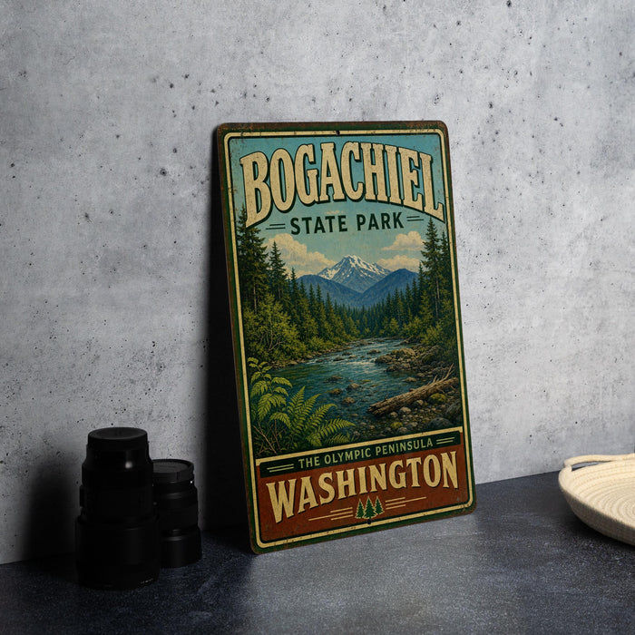 A vintage-style metal sign for Bogachiel State Park, featuring a scenic landscape with mountains, trees, and a river.