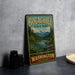 A vintage-style metal sign for Bogachiel State Park, featuring a scenic landscape with mountains, trees, and a river.