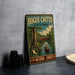 A vintage-style sign for Bogue Chitto State Park, featuring a scenic illustration of a person in a canoe on a river surrounded by lush greenery.
