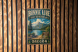 A vintage-style metal sign for Bonnie Lure State Recreation Area in Oregon, featuring a scenic mountain landscape and a sign indicating the location.
