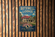 A vintage-style metal sign for the Bothwell Lodge, a historic lodge in Missouri, is displayed on a wooden wall.