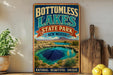 A vintage-style sign for "BOTTOMLESS LAKES STATE PARK NEW MEXICO" featuring a scenic image of a natural lake surrounded by mountains and desert landscapes.