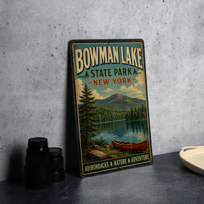 A vintage-style metal sign for Bowman Lake State Park in New York, featuring a scenic image of a lake, mountains, and a canoe.